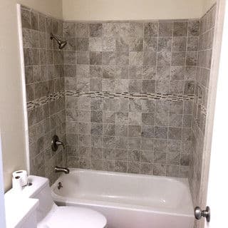 Bathroom with a tiled shower area, bathtub, and modern fixtures.