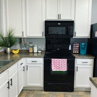 Modern kitchen with black appliances, white cabinets, and a granite countertop.